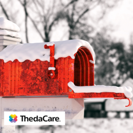 Red mailbox with its door open covered in snow