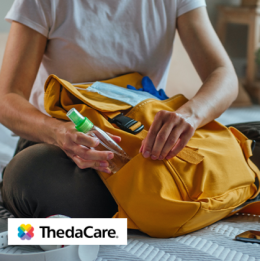Woman packing a backpack with hand sanitizer and other items