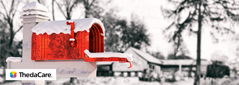 Red mailbox with its door open covered in snow