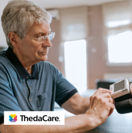 Senior man checking his heart rate and blood pressure at home with a device