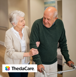 Senior woman walking with senior man that is using a walker