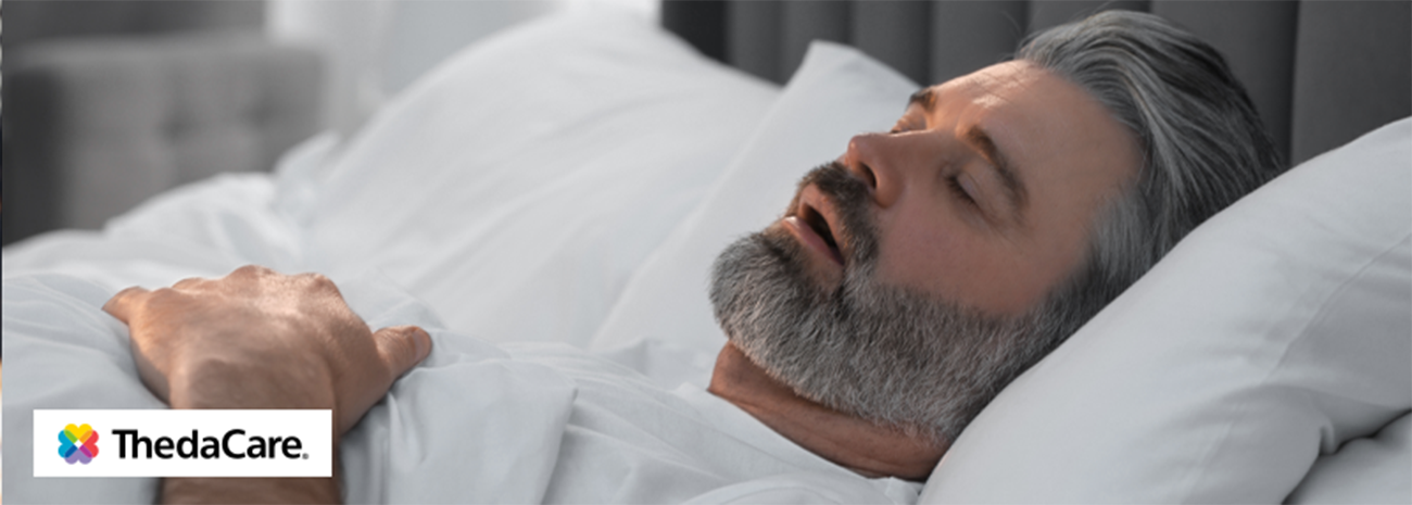 Man lying in bed sleeping with his mouth open