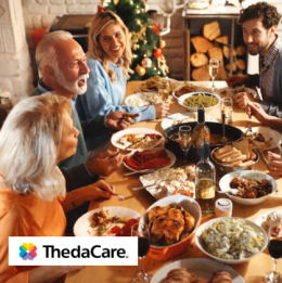 Seniors seated at the table of food with their family during the holidays