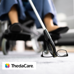 Senior in wheelchair using a reacher to grab their glasses from the floor