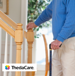 Senior man using cane and holding on to his stair railing
