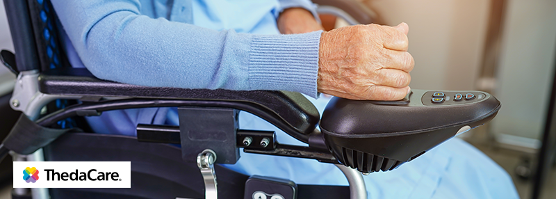 Elderly person using control stick on scooter