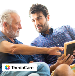 Adult man looking at a photo with his elderly father