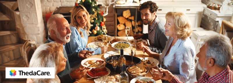 Seniors seated at the table of food with their family during the holidays
