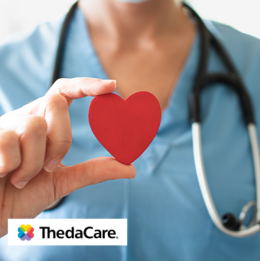 Healthcare professional wearing stethoscope holding a small red heart 