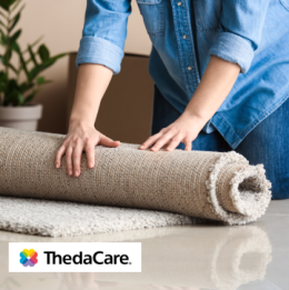 A woman rolling up a rug